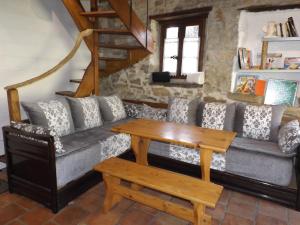 a living room with a couch and a wooden table at Le Gîte des Trois Ruisseaux in Fougaron