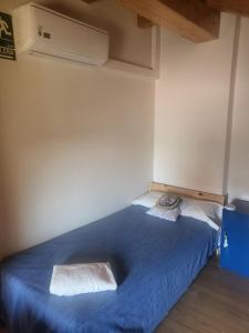 1 dormitorio con 1 cama con colcha azul en Albergue Só Por Hoje , Albergue de Peregrinos del Caminho de Santiago, en Astorga