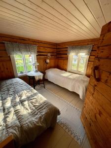 een slaapkamer met 2 bedden in een blokhut bij Lillby Bed&Breakfast 