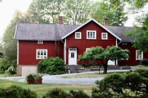 a red barn with a white door at Lillby Bed&Breakfast in Mietoinen