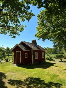 una piccola casa rossa in un campo alberato di Lillby Bed&Breakfast 