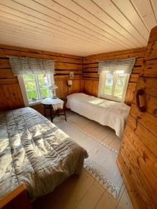 MietoinenにあるLillby Bed&Breakfastの丸太小屋のベッドが2つある寝室