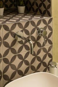 a bathroom sink with a faucet on a wall at Agorà-U CAMAREN in Fasano +14 photos