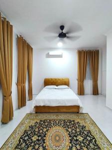 a bedroom with a bed with a ceiling fan and a rug at YY Homestay Pasir Mas in Pasir Mas +13 photos