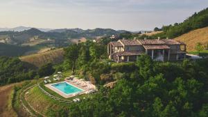 an aerial view of a house on a hill with a swimming pool at Country House Ca'Balsomino in Urbino
