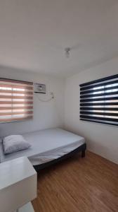 sypialnia z łóżkiem w pokoju z oknem w obiekcie Brand New Camella 2 Bedroom House w mieście Butuan