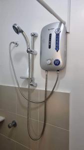 a shower in a bathroom with a blow dryer at Brand New Camella 2 Bedroom House in Butuan