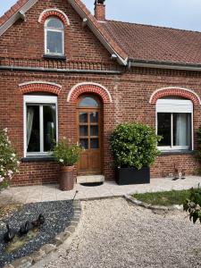 una casa de ladrillo con puerta y ventanas marrones en Maison 90 m2 (Logement complet), en Miraumont