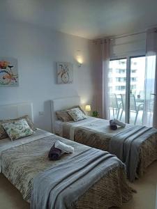 a bedroom with two beds with towels on them at Apartamento Panorama Mar in Punta Prima +42 photos