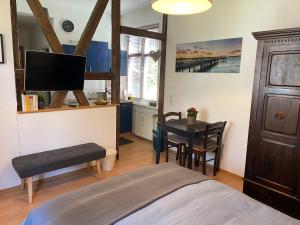 a bedroom with a bed and a table and a tv at Ferienwohnung Casa Conti Goslar in Goslar