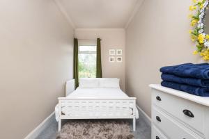 1 dormitorio con cuna blanca y ventana en Horbury High St Wakefield en Horbury