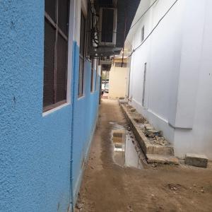 eine Gasse mit einer blauen Wand und einer Pfütze Wasser in der Unterkunft Baraste zanzibar in Ngambo