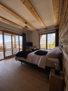 sypialnia z dużym łóżkiem w pokoju z oknami w obiekcie Les Arcs - Chalet Arc Ô Mont w mieście Arc 1600