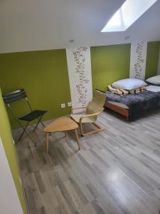ein Schlafzimmer mit einem Bett, einem Stuhl und einem Tisch in der Unterkunft La maison dans les noyer in Sainte-Eulalie