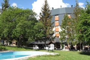 ein Resort mit einem Swimmingpool vor einem Gebäude in der Unterkunft Hotel Or Blanc in Espot