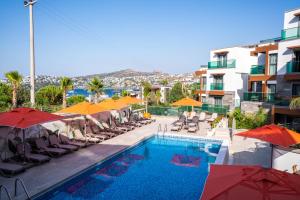 une piscine avec des chaises et des parasols dans l'établissement Palm Hills Bodrum Hotel, à Bodrum City