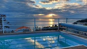 uma piscina num navio de cruzeiro com o pôr-do-sol em Flaghouse na Calheta