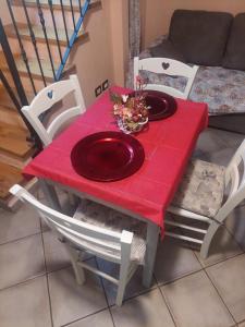 a red table with chairs and a red plate on it at Casa campagna bosco in Frassineta