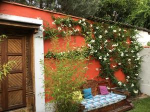 un banc avec des fleurs sur le côté du bâtiment dans l'établissement CHAMBRES chez l'habitant Córdoba et Lhassa, à Bordeaux