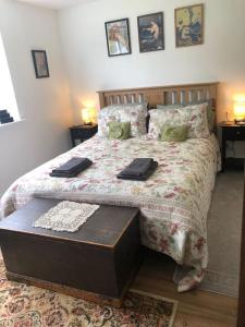 ein Schlafzimmer mit einem Bett mit zwei Tabletts drauf in der Unterkunft Detached Cottage Yards from the Beach in Chapel Saint Leonards