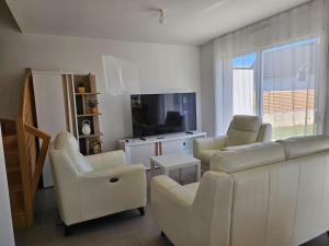 プロムールにあるMaison accès PMR PERSONNE A MOBILITE REDUITE sur Ploemeur proche Lorientのソファと椅子とテレビのあるリビングルーム