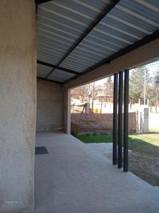 un edificio vacío con techo de metal sobre un patio en Casa Moderna en Mina Clavero
