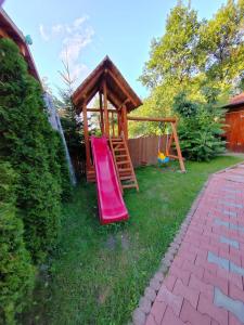 einen Spielplatz mit Rutsche und Holzpavillon in der Unterkunft LaSovataa in Sovata