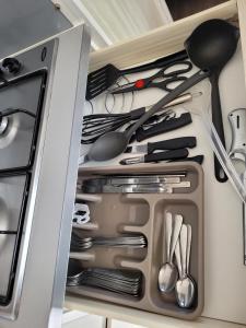 a drawer filled with utensils in a refrigerator at Mobilhome clim La Falaise 4 étoiles in Narbonne