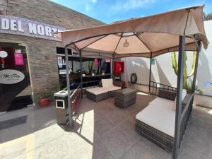 a patio with an umbrella in front of a building at Hotel Portal del Norte in Copiapó