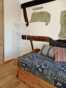 - une chambre dotée d'un lit avec une couverture bleue et blanche dans l'établissement Ferienwohnung im Auszeithaus Hohenlohe, à Forchtenberg