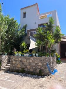 a building with potted plants in front of it at Elena Limnos Beach in Volissos