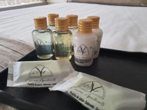 four bottles of essential oils on a tray on a bed at Camões Apartments in Ponte de Lima