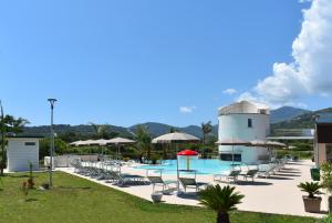 una piscina con sillas y una torre de agua en Hyele Accommodation Experience, en Casal Velino