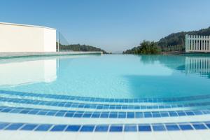 uma piscina com água azul e montanhas ao fundo em LA CASA DEL PANTANO em La Vall de Laguar