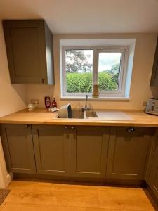 a kitchen with a sink and a window at Beautiful mid wales cottage in Garth