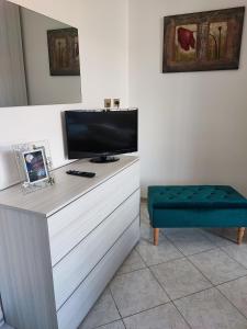 einen Schreibtisch mit einem TV und einem blauen Stuhl in der Unterkunft Casa Vacanze Parco del Sole in Rom