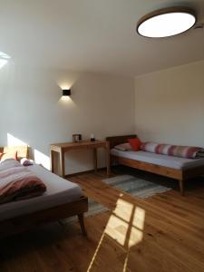 Cette chambre comprend 2 lits et une table. dans l'établissement Ferienwohnung im Auszeithaus Hohenlohe, à Forchtenberg