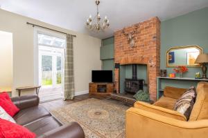 a living room with a couch and a fireplace at Canal Side Cottage Wakefield in Stanley