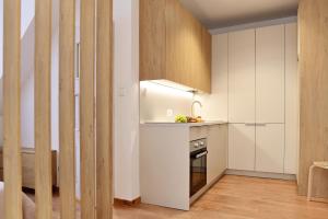 uma cozinha com armários brancos, um lavatório e um fogão em Agroturystyka Wilcza Wola 