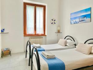 a room with two beds and a window at Ca del Mare - FREE Parking in La Spezia