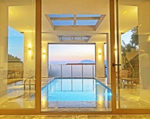 a house with a swimming pool inside of it at Villa With a Private Heated Pool, Jacuzzi, Overlooking Spectacular Views Of The Sea in Kaş