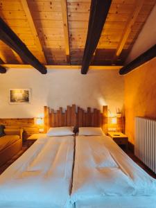 a large bed in a room with wooden ceilings at Malga Millegrobbe Nordic Resort in Lavarone