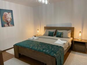 - une chambre avec un grand lit et une couverture verte dans l'établissement Aminah House, à Constanţa