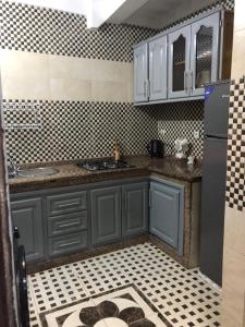 a kitchen with blue cabinets and a tile floor at Casa Del Flor in Larache