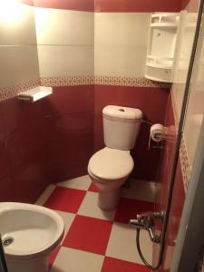 a red and white bathroom with a toilet and sink at Casa Del Flor in Larache