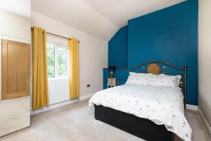 ein Schlafzimmer mit einer Wand mit blauen Akzenten und einem Bett in der Unterkunft Canal Side Cottage Wakefield in Stanley