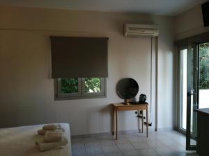 a bedroom with a bed with a window and a fan at Filanthi CostaS in Stoupa