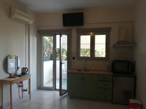 a kitchen with a sink and a tv on the wall at Filanthi CostaS in Stoupa