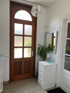 baño con puerta de madera y espejo en Maison 90 m2 (Logement complet), en Miraumont