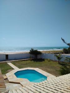 - une piscine avec la plage en arrière-plan dans l'établissement Casa de Praia no Morro Branco, à Beberibe